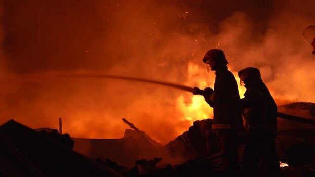 View of firefighters battling a large fire at night Bangladesh. View of firefighters battling a large fire at night Bangladesh.