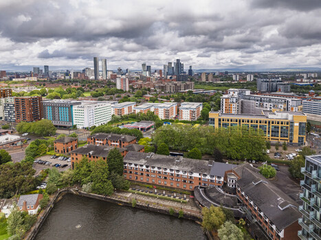 Aerial view of MediaCityUK and the surrounding urban landscape of Salford featuring modern office buildings residential complexes and green spaces in Salford England United Kingdom. Aerial view of MediaCityUK and the surrounding urban landscape of Salford featuring modern office buildings residential complexes and green spaces in Salford England United Kingdom.