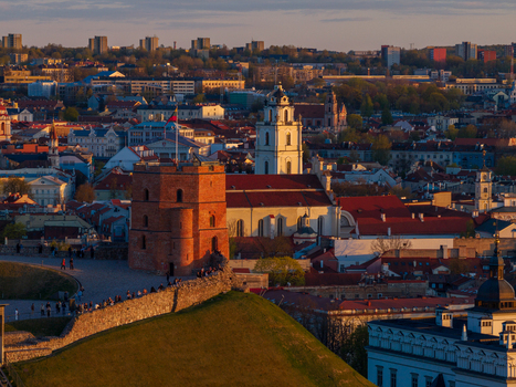 Aerial view of Gediminas Tower on a hill overlooking the historic rooftops and church towers of the old town during sunset Vilnius County Lithuania. Aerial view of Gediminas Tower on a hill overlooking the historic rooftops and church towers of the old town during sunset Vilnius County Lithuania.