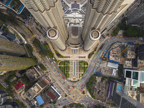 Kuala Lumpur Malaysia 11 March 2026 Aerial view of the Petronas Twin Towers looking straight down at the skybridge surrounding city streets and urban architecture.