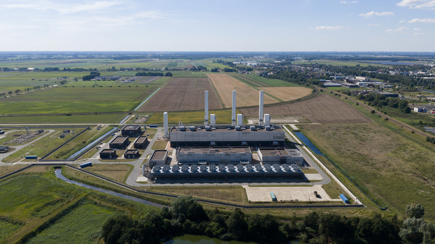 Aerial view of the Gasunie and Air Products nitrogen factory featuring tall chimneys and cooling units surrounded by agricultural fields in Muntendam Groningen Netherlands.