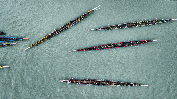 Baghabari Rajshahi Division Bangladesh 20 August 2022 Aerial view of a traditional boat race with long narrow boats filled with numerous rowers navigating the river waters.