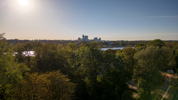 Aerial view of lush green canopy stretches towards the Vistula River and the city skyline a vibrant tapestry under the sun s warm glow Warsaw Poland. Aerial view of lush green canopy stretches towards the Vistula River and the city skyline a vibrant tapestry under the sun s warm glow Warsaw Poland.