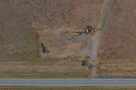 Aerial view of construction equipment parked on a dirt lot next to a paved road in Golden Colorado United States.