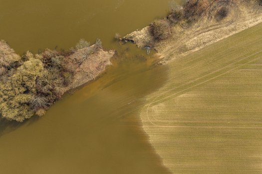 Aerial view of flooded agricultural fields and riverbanks with murky water and bare trees in Kaniukai Kaunas County Lithuania. Aerial view of flooded agricultural fields and riverbanks with murky water and bare trees in Kaniukai Kaunas County Lithuania.
