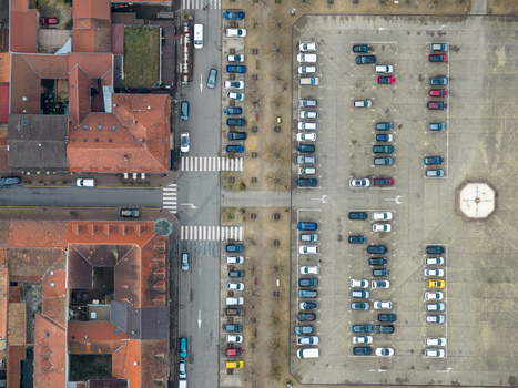 Aerial view of orderly parked cars juxtapose historic red roofed buildings in a symmetrical streetscape Neuf Brisach Grand Est France.