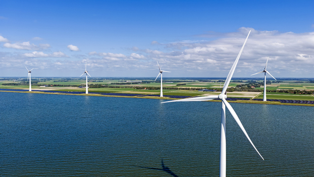Aerial view of wind turbines standing in the water along the green coastline of Rutten Flevoland Netherlands. Aerial view of wind turbines standing in the water along the green coastline of Rutten Flevoland Netherlands.