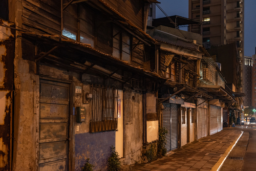 View of traditional wooden houses with weathered facades and closed metal shutters along a quiet street in Zhongzheng District Taipei City Taiwan. View of traditional wooden houses with weathered facades and closed metal shutters along a quiet street in Zhongzheng District Taipei City Taiwan.