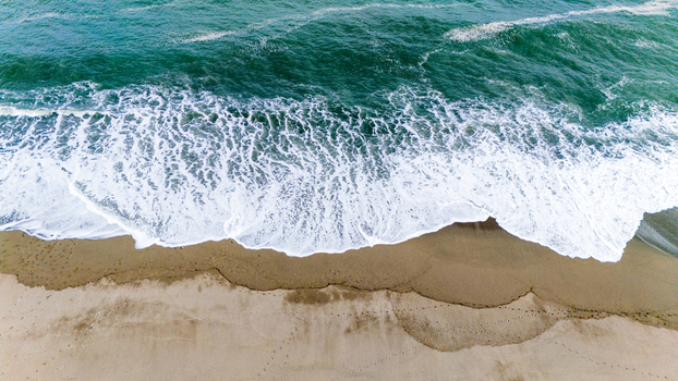 Aerial view of the mesmerizing dance of turquoise waves crashing onto the golden sand Ship Creek Haast West Coast Region New Zealand. Aerial view of the mesmerizing dance of turquoise waves crashing onto the golden sand Ship Creek Haast West Coast Region New Zealand.