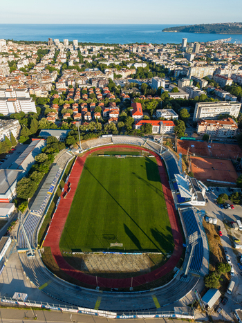 Varna Varna Bulgaria 23 June 2026 Aerial view of Spartak Stadium with green pitch and red running track surrounded by urban buildings with the Black Sea background.