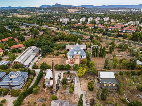 Aerial view of the restored air distillery and industrial buildings at the former Obuda Gasworks surrounded by railway lines trees and housing in Budapest Hungary. Aerial view of the restored air distillery and industrial buildings at the former Obuda Gasworks surrounded by railway lines trees and housing in Budapest Hungary.