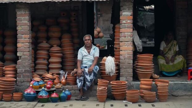 View of a potter with clay vessels in Chapai Nawabganj Bangladesh. View of a potter with clay vessels in Chapai Nawabganj Bangladesh.