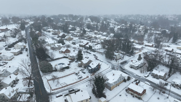 Aerial view of Lynchburg covered in a blanket of fresh snow featuring residential houses tree lined streets and quiet suburban neighborhoods in Lynchburg Virginia United States.