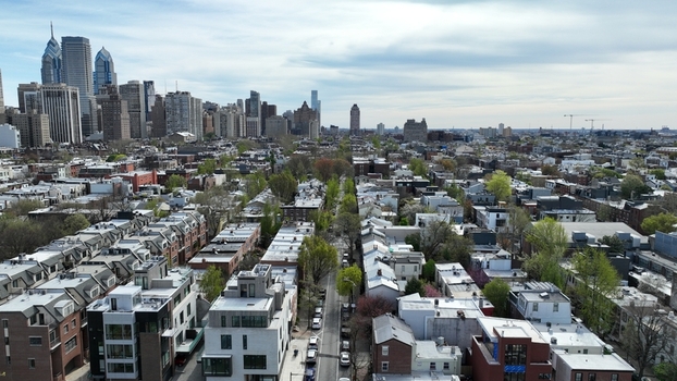 Aerial view of a street lined with trees and buildings leading to the Philadelphia skyline a tapestry of concrete and glass against a pale sky Philadelphia Pennsylvania United States.