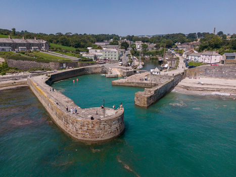 Aerial view of Charlestown Harbour with its historic stone piers turquoise water and surrounding village buildings in Charlestown Cornwall United Kingdom. Aerial view of Charlestown Harbour with its historic stone piers turquoise water and surrounding village buildings in Charlestown Cornwall United Kingdom.