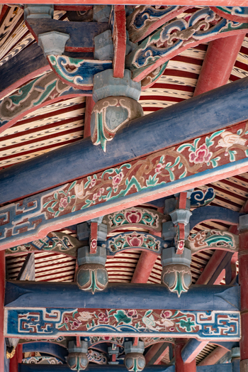 View of the intricate hand painted traditional Chinese roof beams and ornate dougong brackets featuring floral motifs at Chihkan Tower in Chihkan Village Tainan City Taiwan. View of the intricate hand painted traditional Chinese roof beams and ornate dougong brackets featuring floral motifs at Chihkan Tower in Chihkan Village Tainan City Taiwan.