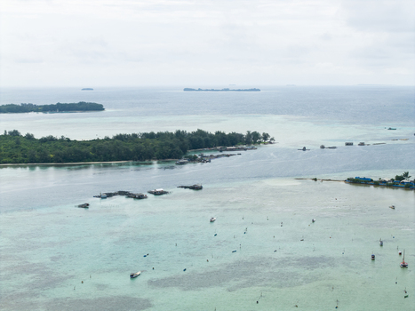 Aerial view of turquoise waters meet lush green islands a serene seascape dotted with stilt houses and boats Karimunjawa Central Java Indonesia. Aerial view of turquoise waters meet lush green islands a serene seascape dotted with stilt houses and boats Karimunjawa Central Java Indonesia.