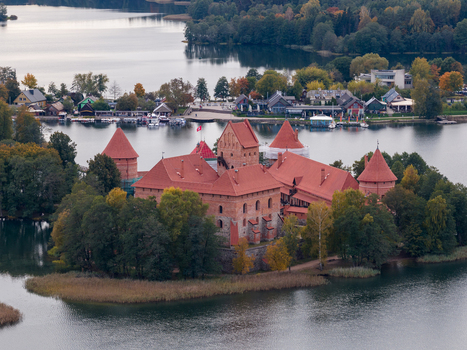 Aerial view of Trakai Island Castle surrounded by lush green trees and the calm waters of Lake Galve with the town in the background Trakai Vilniaus apskritis Lithuania.