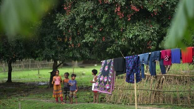 View of children standing near a lychee tree in Bogura Bangladesh.