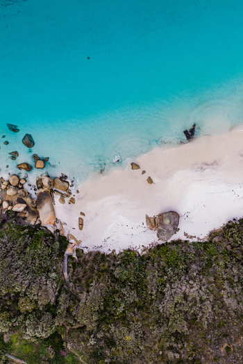 Aerial view of Frenchman Bay with turquoise water white sand scattered granite boulders and dense coastal vegetation in Albany Western Australia Australia. Aerial view of Frenchman Bay with turquoise water white sand scattered granite boulders and dense coastal vegetation in Albany Western Australia Australia.