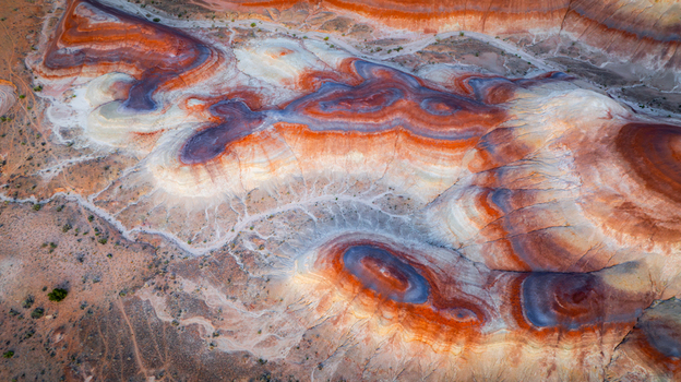 Aerial view of the colorful bentonite hills badlands with vibrant red purple and white clay layers and intricate erosion patterns in Hanksville Utah United States.