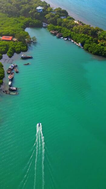 Aerial view of a boat in turquoise waters Honduras.