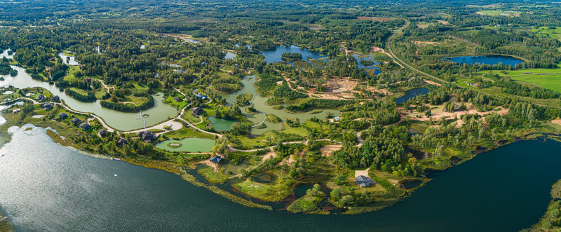 Aerial view of interconnected lakes lush green forests and scattered residential houses nestled among the natural terrain in Latvia. Aerial view of interconnected lakes lush green forests and scattered residential houses nestled among the natural terrain in Latvia.