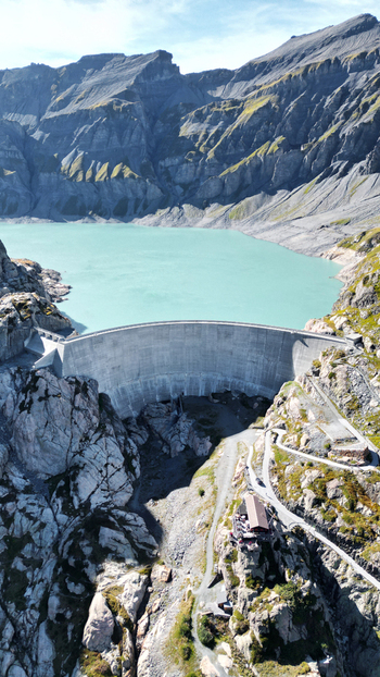 Aerial view of the dam and Vieux Emosson lake surrounded by rugged alpine mountains and rocky terrain in Finhaut Valais Switzerland. Aerial view of the dam and Vieux Emosson lake surrounded by rugged alpine mountains and rocky terrain in Finhaut Valais Switzerland.
