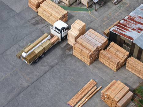 Melbourne Australia 25 September 2026 Aerial view of a truck loaded with stacks of lumber in a factory yard with wooden pallets and industrial machinery.