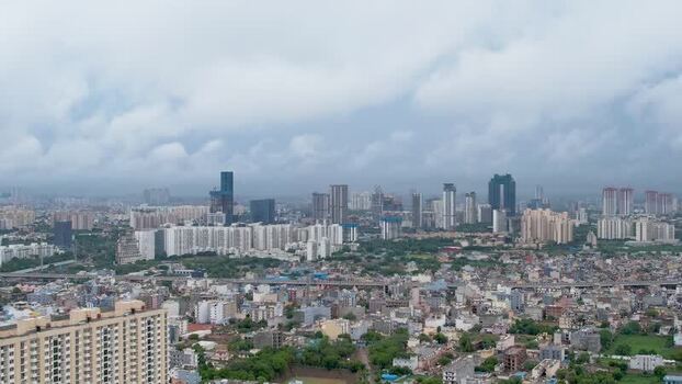 Aerial view of Gurugram skyscrapers under monsoon clouds India.
