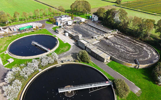 Aerial view of the wastewater treatment plant at Schagerweg 2 with circular sedimentation tanks and aeration basins surrounded by green fields in Schagerbrug Noord Holland Netherlands. Aerial view of the wastewater treatment plant at Schagerweg 2 with circular sedimentation tanks and aeration basins surrounded by green fields in Schagerbrug Noord Holland Netherlands.
