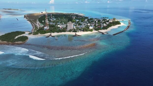 Aerial view of Thulusdhoo island and turquoise waters Maldives.