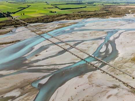 Aerial view of the braided Rangitata River carving through the Canterbury Plains with a bridge cutting across the turquoise waters New Zealand. Aerial view of the braided Rangitata River carving through the Canterbury Plains with a bridge cutting across the turquoise waters New Zealand.