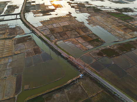Aerial view of geometric salt pans and water channels reflecting the golden sunset light in Moheskhali Upazila Chittagong Division Bangladesh. Aerial view of geometric salt pans and water channels reflecting the golden sunset light in Moheskhali Upazila Chittagong Division Bangladesh.