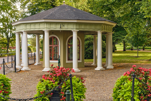 Ronneby Blekinge County Sweden 11 September 2025 View of the historic Brunssparken rotunda with white columns surrounded by lush trees and vibrant flower beds. Ronneby Blekinge County Sweden 11 September 2025 View of the historic Brunssparken rotunda with white columns surrounded by lush trees and vibrant flower beds.