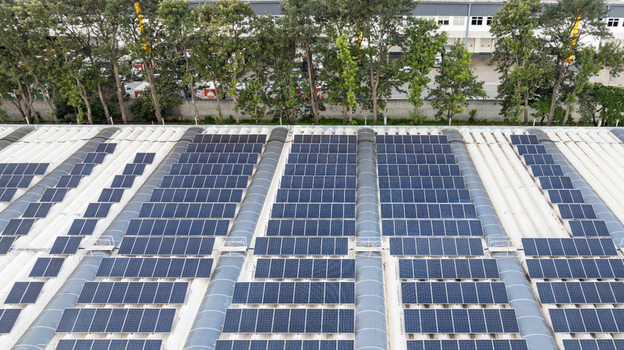 Aerial view of the solar power plant installation on the roof of the Mercado Livre headquarters with rows of photovoltaic panels and surrounding trees in Osasco State of Sao Paulo Brazil.