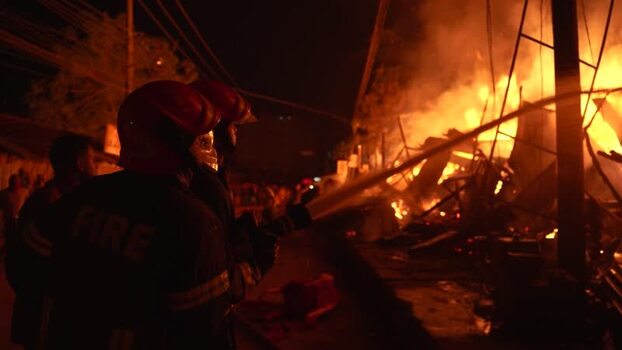 View of firefighters battling a massive blaze at night Bangladesh. View of firefighters battling a massive blaze at night Bangladesh.