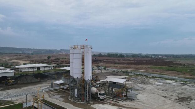 Aerial view of the Dhoho International Airport construction site featuring concrete silos heavy machinery and surrounding earthworks under a cloudy sky in Kecamatan Grogol Jawa Timur Indonesia. Aerial view of the Dhoho International Airport construction site featuring concrete silos heavy machinery and surrounding earthworks under a cloudy sky in Kecamatan Grogol Jawa Timur Indonesia.