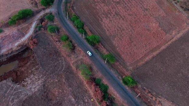 Aerial view of a car on a rural road in Ankleshwar India.