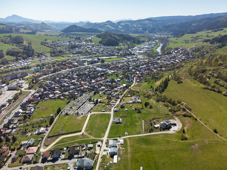 Aerial view of the town of Nizna with its residential houses cemetery and winding river surrounded by lush green hills and mountains in Nizna Zilina Region Slovakia. Aerial view of the town of Nizna with its residential houses cemetery and winding river surrounded by lush green hills and mountains in Nizna Zilina Region Slovakia.