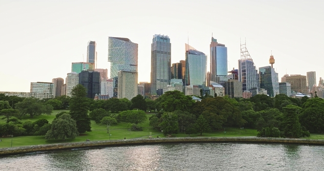 Aerial view of the modern skyline featuring glass skyscrapers and the Sydney Tower rising above the Royal Botanic Garden and harbor waters Sydney New South Wales Australia. Aerial view of the modern skyline featuring glass skyscrapers and the Sydney Tower rising above the Royal Botanic Garden and harbor waters Sydney New South Wales Australia.
