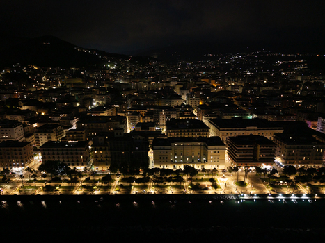Aerial view of the city at night with illuminated buildings and waterfront promenade in Salerno Campania Italy.
