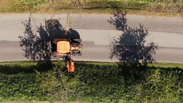 Aerial view of a tractor mowing grass on a roadside Czechia.