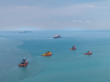 George Town Malaysia 22 September 2026 Aerial view of multiple tugboats and vessels navigating the calm blue waters near the Penang Bridge under a cloudy sky. George Town Malaysia 22 September 2026 Aerial view of multiple tugboats and vessels navigating the calm blue waters near the Penang Bridge under a cloudy sky.