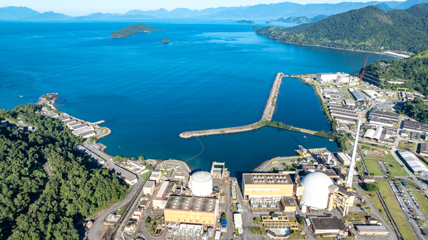 Aerial view of the Nuclear Power Plant Angra 2 with its white containment domes industrial buildings and tall chimney situated along the coastline of Angra dos Reis Rio de Janeiro Brazil.