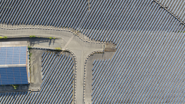 Aerial view of a large solar farm with rows of photovoltaic panels and a building with solar panels on the roof in Ludwigshafen Rhineland Palatinate Germany. Aerial view of a large solar farm with rows of photovoltaic panels and a building with solar panels on the roof in Ludwigshafen Rhineland Palatinate Germany.