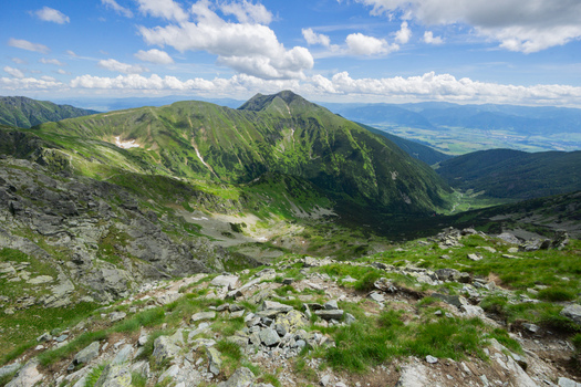 View of Tri kopy in Western Tatras with green mountain ridges rocky slopes and a deep valley under a blue sky with fluffy clouds in Ziar Zilina Region Slovakia. View of Tri kopy in Western Tatras with green mountain ridges rocky slopes and a deep valley under a blue sky with fluffy clouds in Ziar Zilina Region Slovakia.