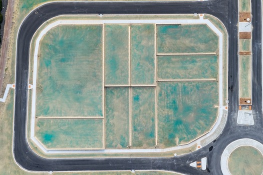Aerial view of a new residential development site with subdivided plots green hydroseeding and paved roads in Perth Western Australia Australia. Aerial view of a new residential development site with subdivided plots green hydroseeding and paved roads in Perth Western Australia Australia.