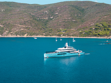 Aerial view of the luxury yacht Netto II anchored in the clear blue waters of Lacona Bay surrounded by green hills on the island of Elba in Lacona Tuscany Italy.