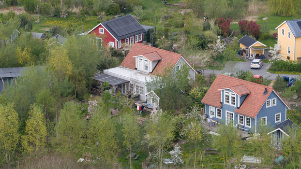 Aerial view of the colorful wooden houses and sustainable gardens of Ecodorp Bolderburen surrounded by lush greenery and spring blossoms in Almere Flevoland Netherlands. Aerial view of the colorful wooden houses and sustainable gardens of Ecodorp Bolderburen surrounded by lush greenery and spring blossoms in Almere Flevoland Netherlands.
